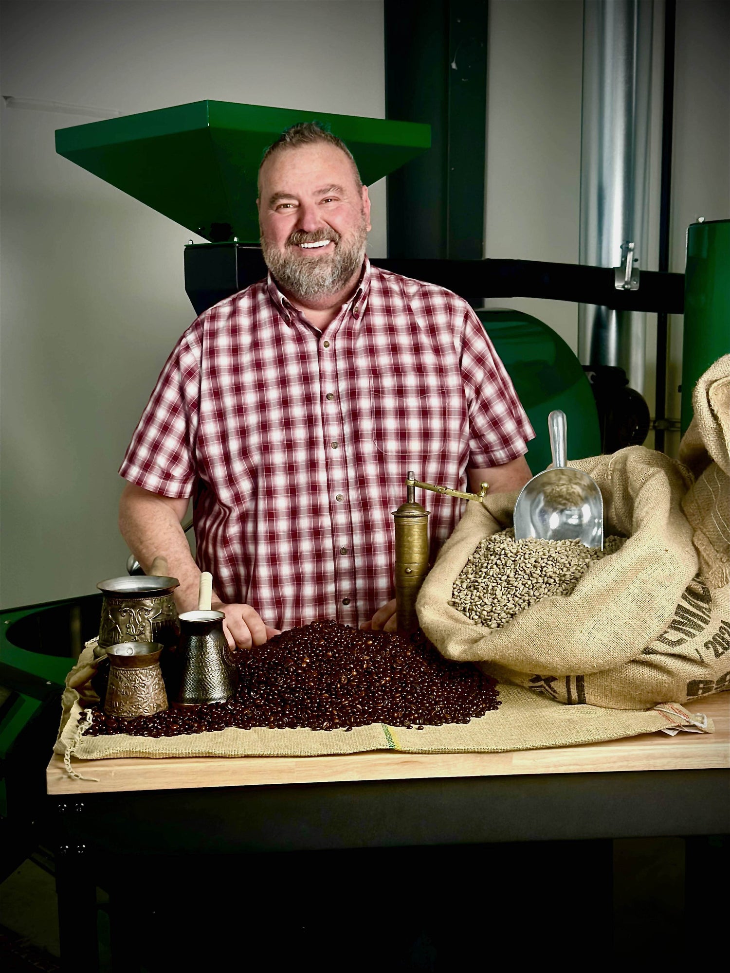Chef Vatche Moukhtarian, owner of Sanctuary Coffee Roasting, standing with coffee beans and roasting equipment.